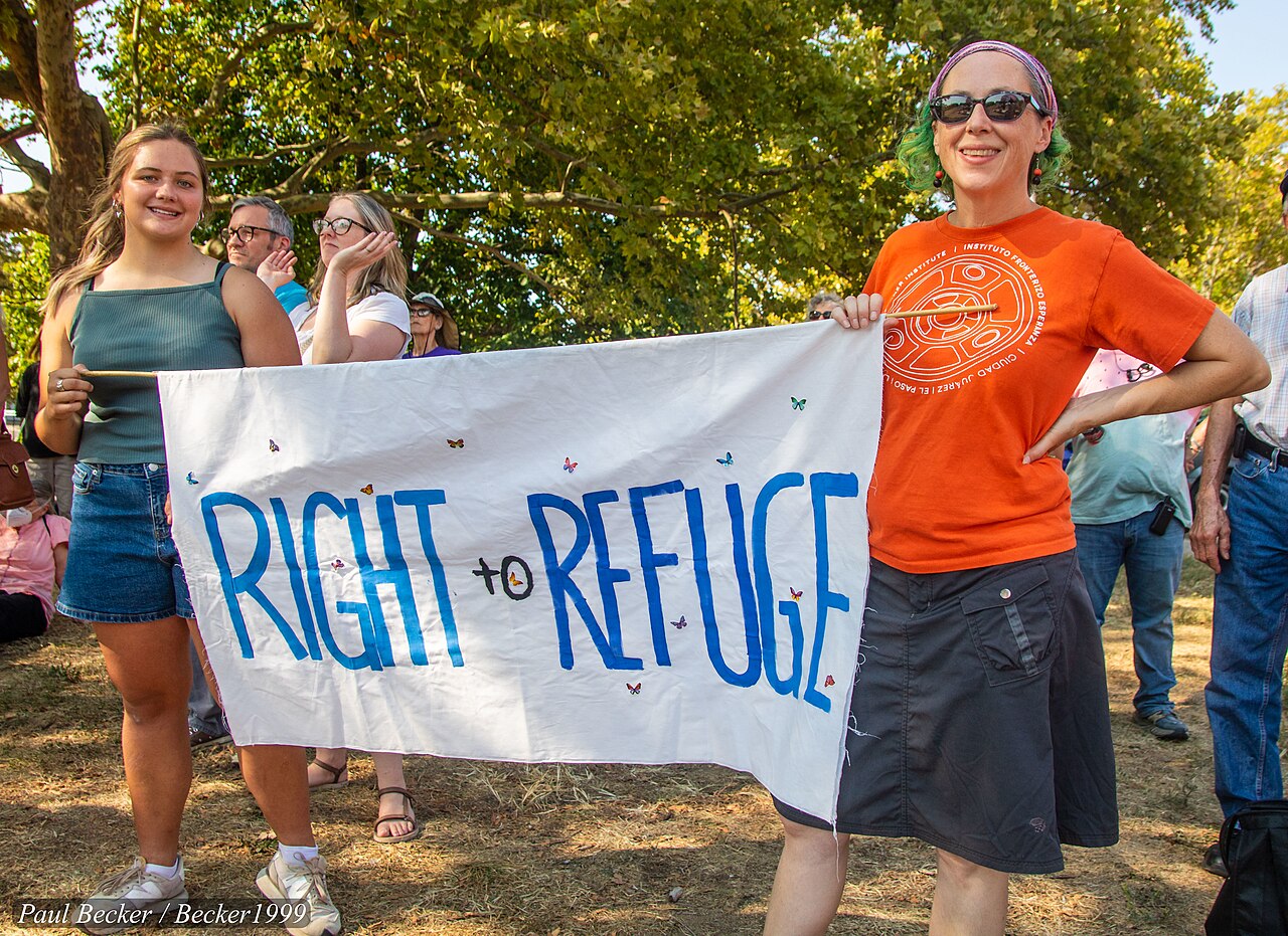 Marchers hold a hand-painted Right to Refuge banner at a rally in support of Springfield's Haitian community in Dayton, Ohio